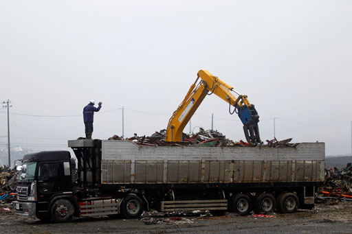 A construction machine loads iron debris on a truck at a devastated area in Minamisanriku, Miyagi Prefecture, northeastern Japan, Saturday, April 23, 2011. (AP Photo/Hiro Komae)