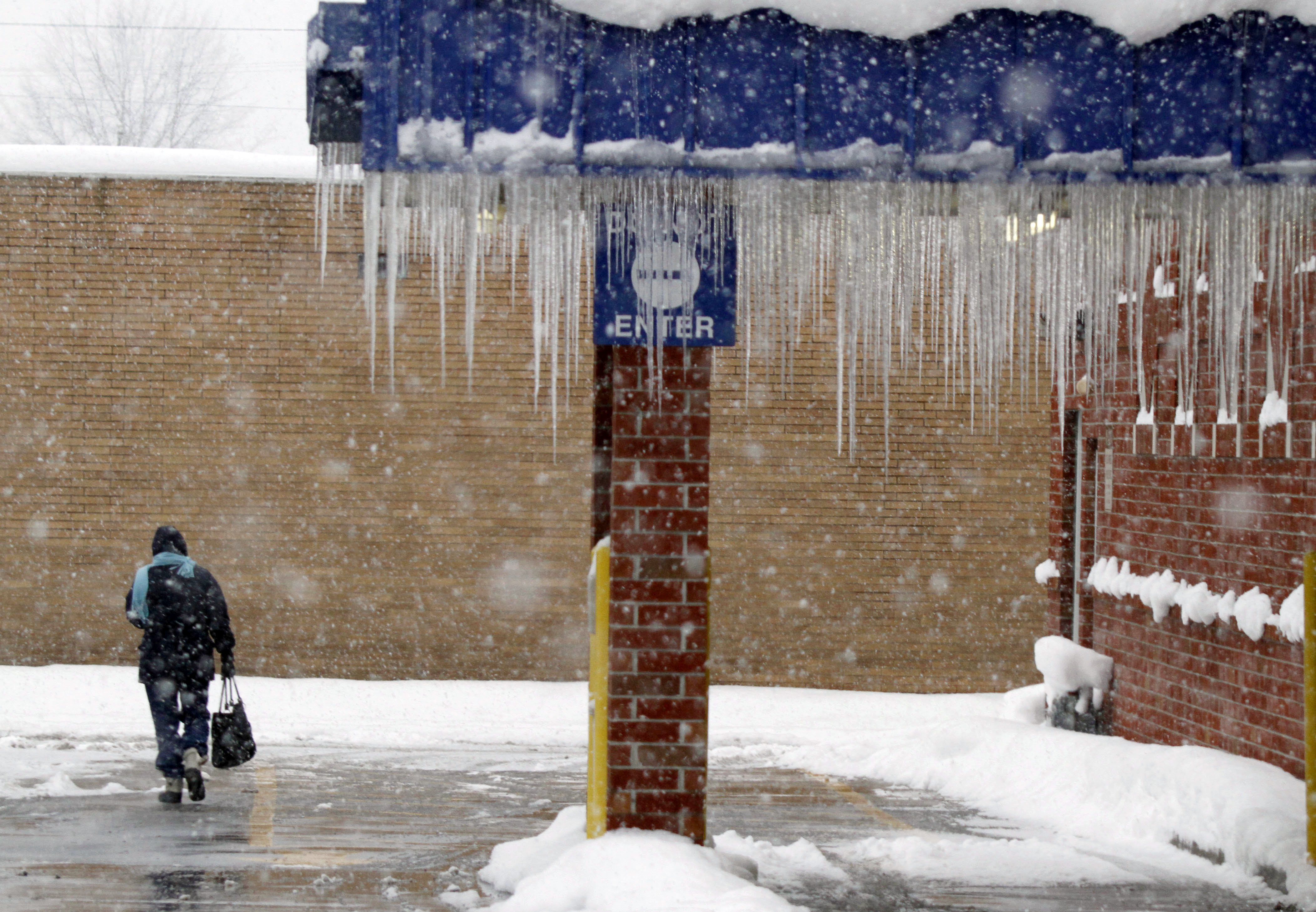 Icicles on drive-thru overhang with woman walking