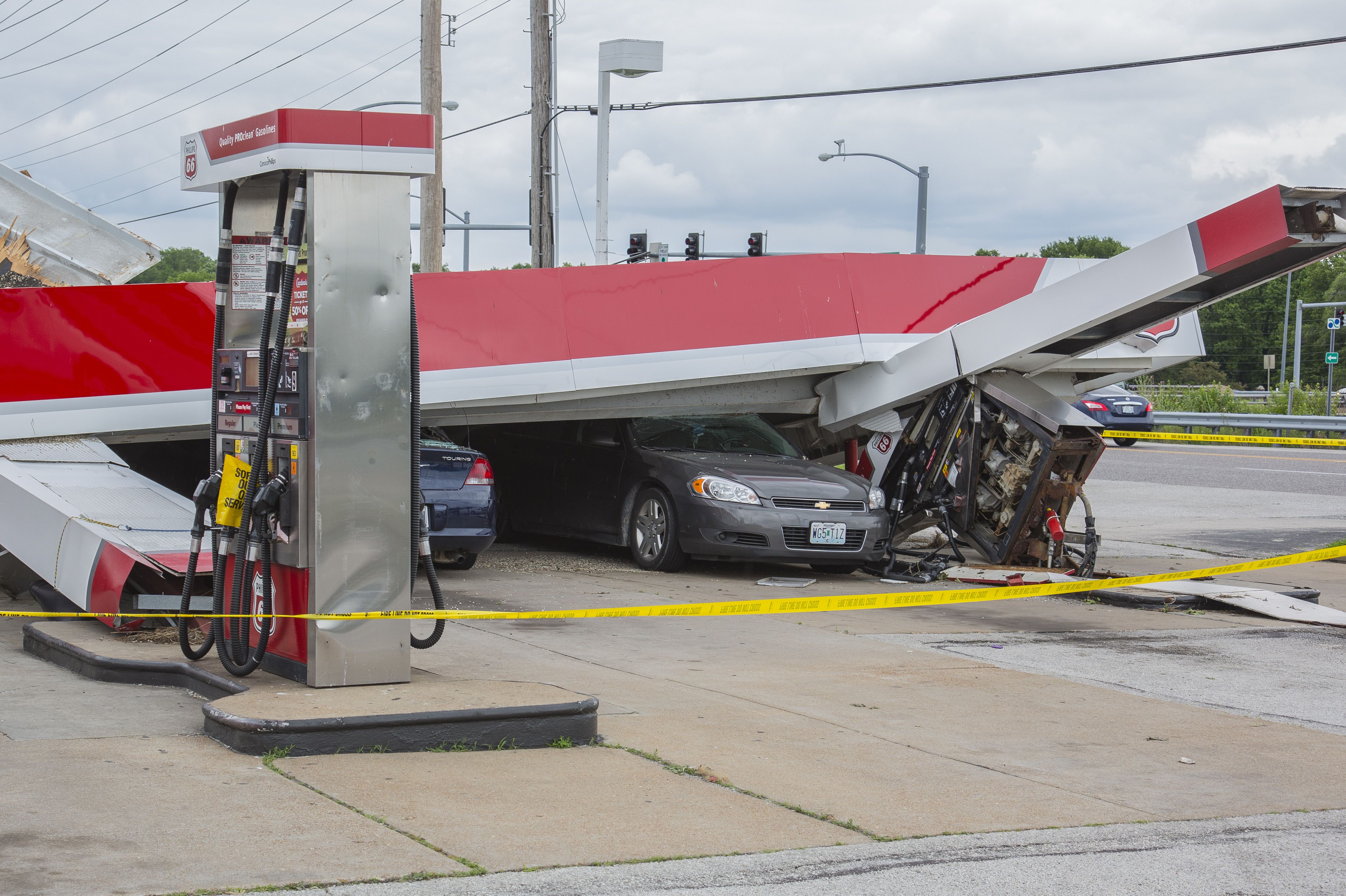 tornado damaged cars under gas station awning
