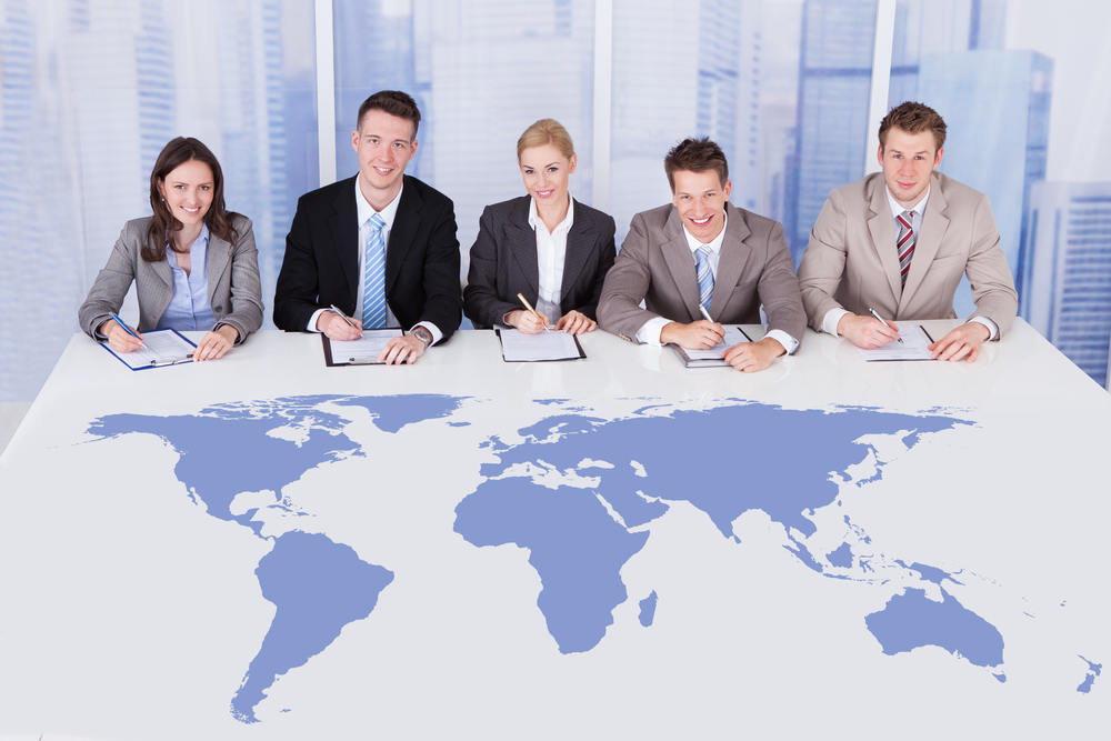 Business-people-sitting-at-table-with-world-map-SS-Andrey_Popov