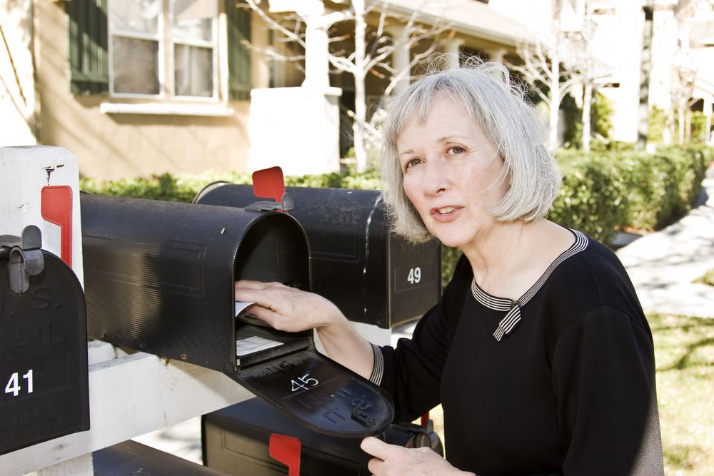 woman getting mail from mailbox