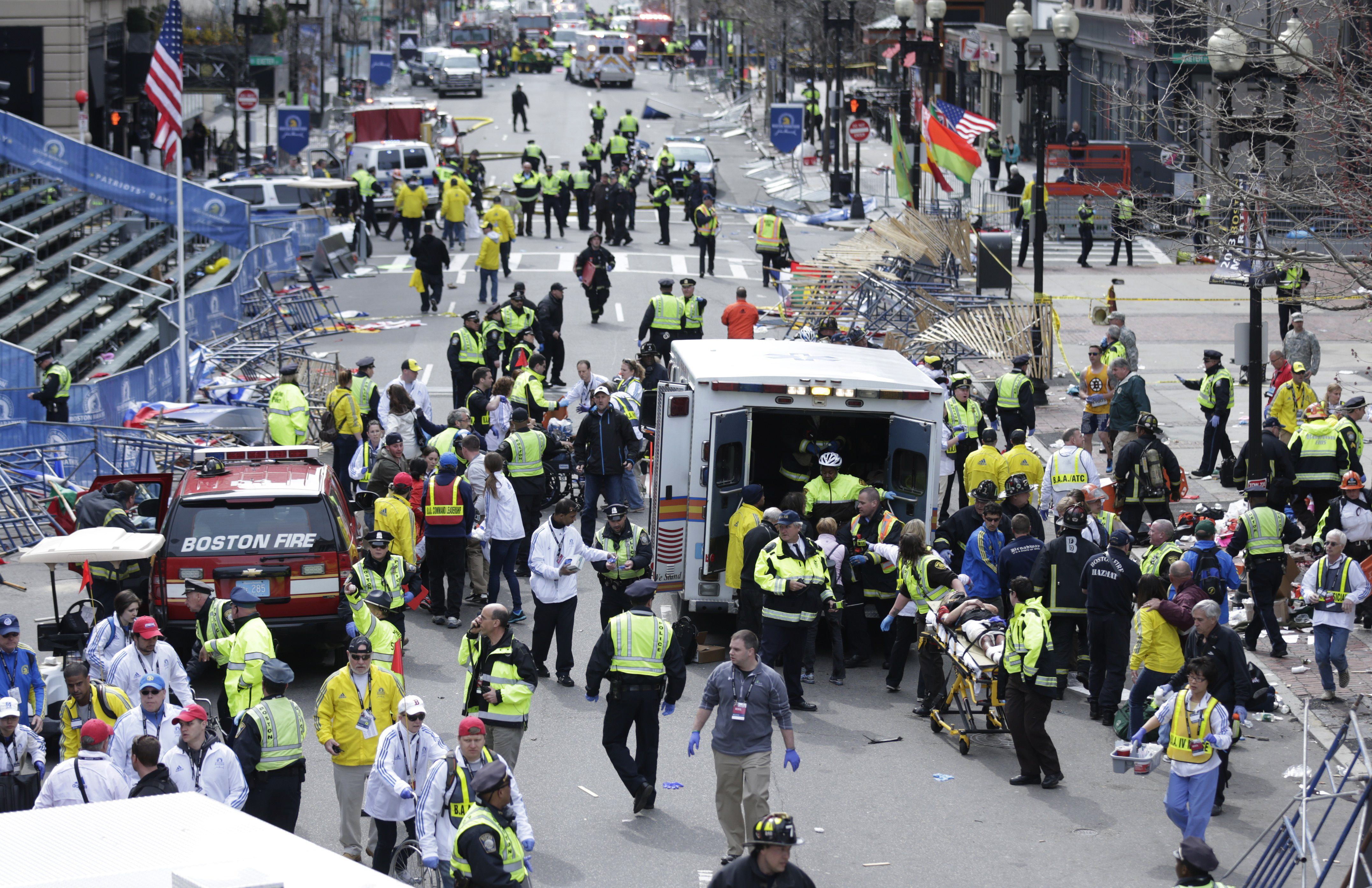 Medical workers aid injured people at the finish line of the 2013 Boston Marathon following an explosion