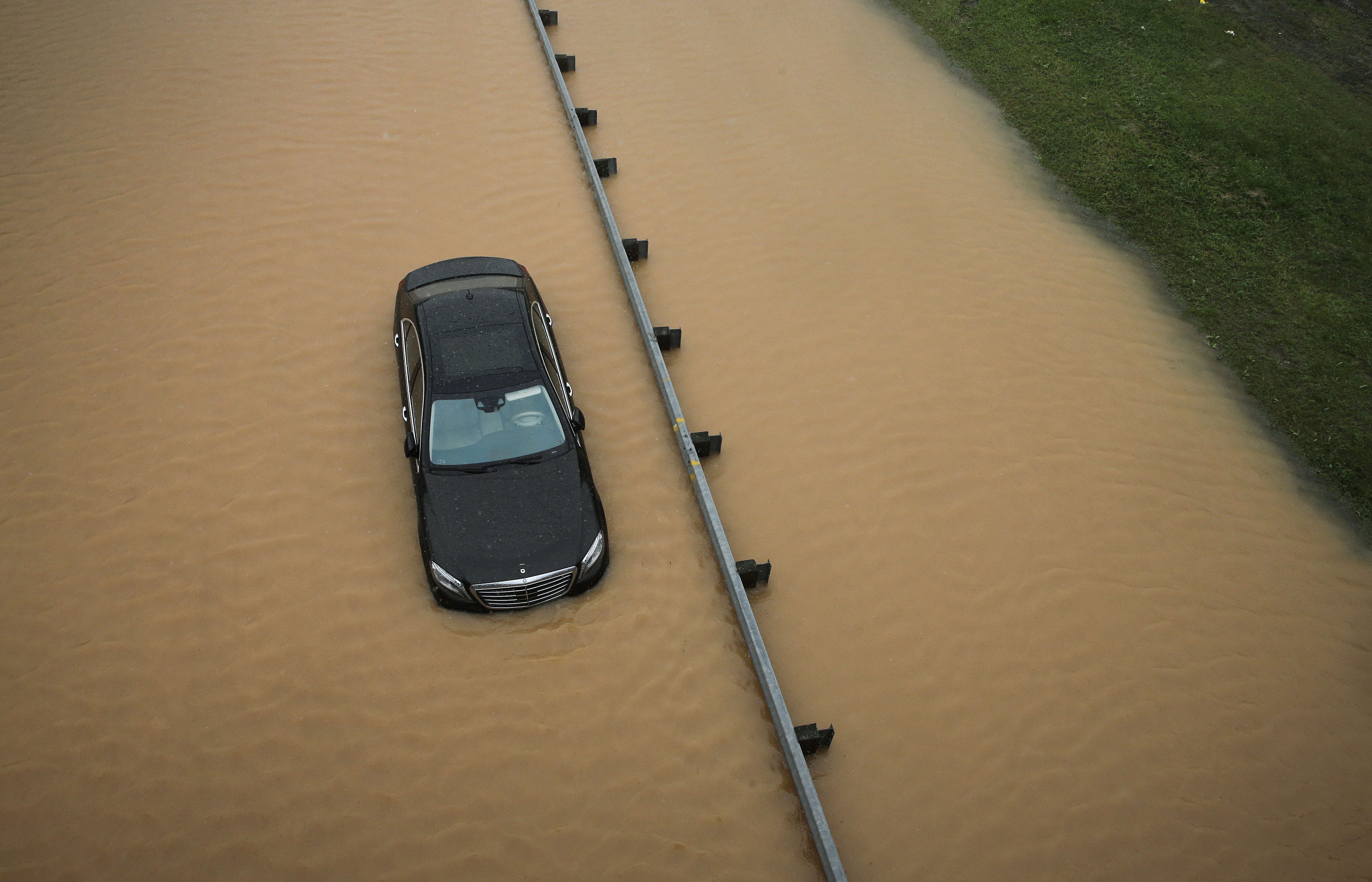 A partially submerged car sits on a flooded section of nterstate 695 in Baltimore
