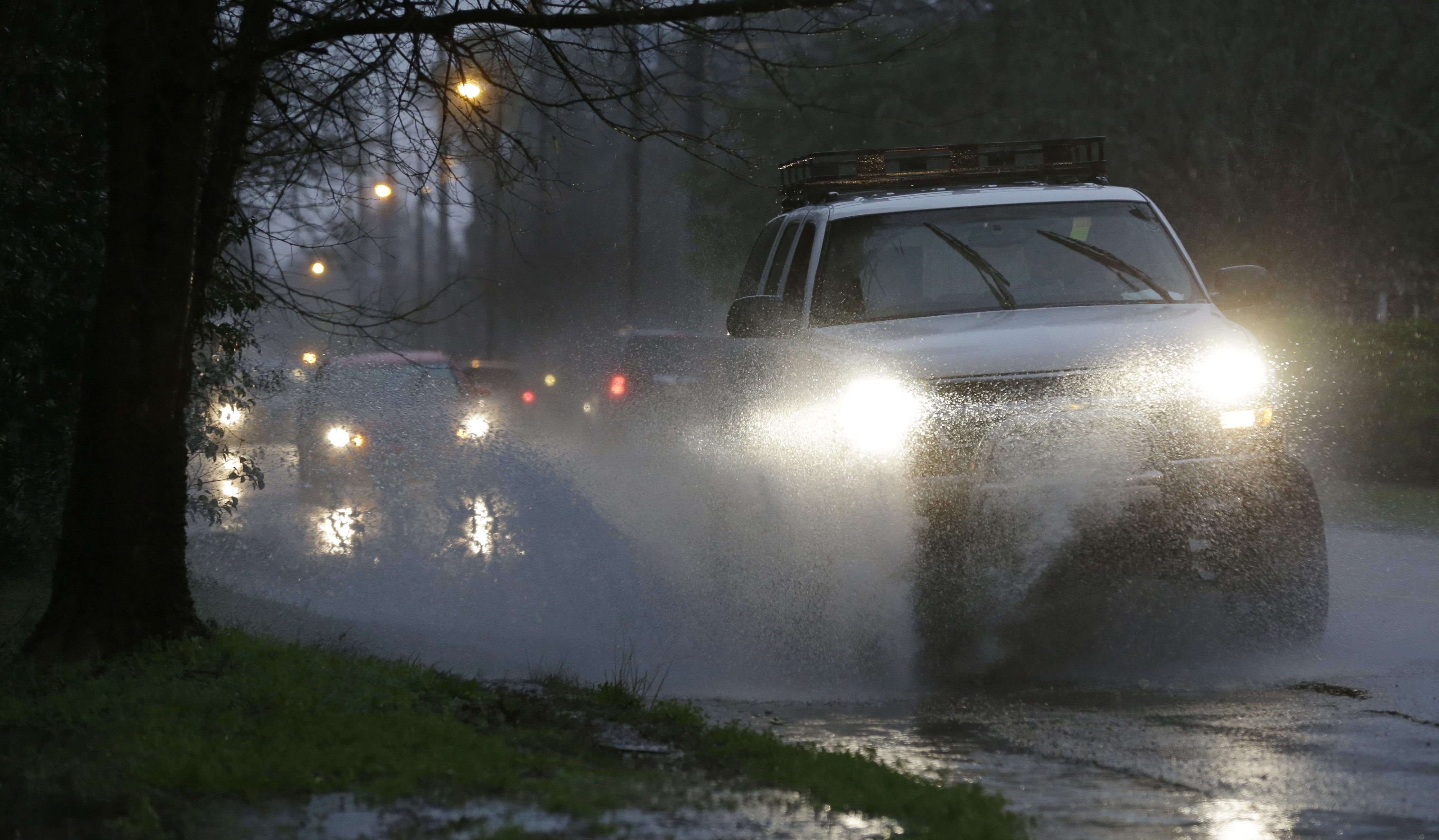 Rush hour traffic drives through minor street flooding in Montgomery, Ala., Tuesday, Feb. 12, 2013.