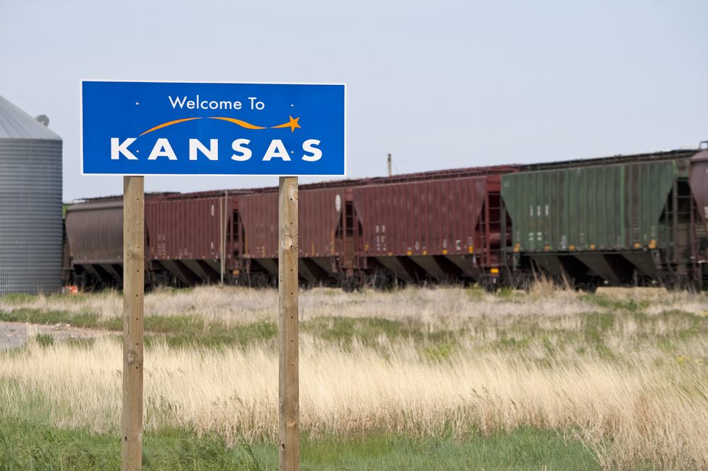 Welcome to Kansas sign with train in background