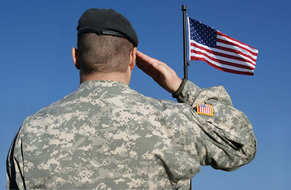 American soldier saluting the U.S. flag