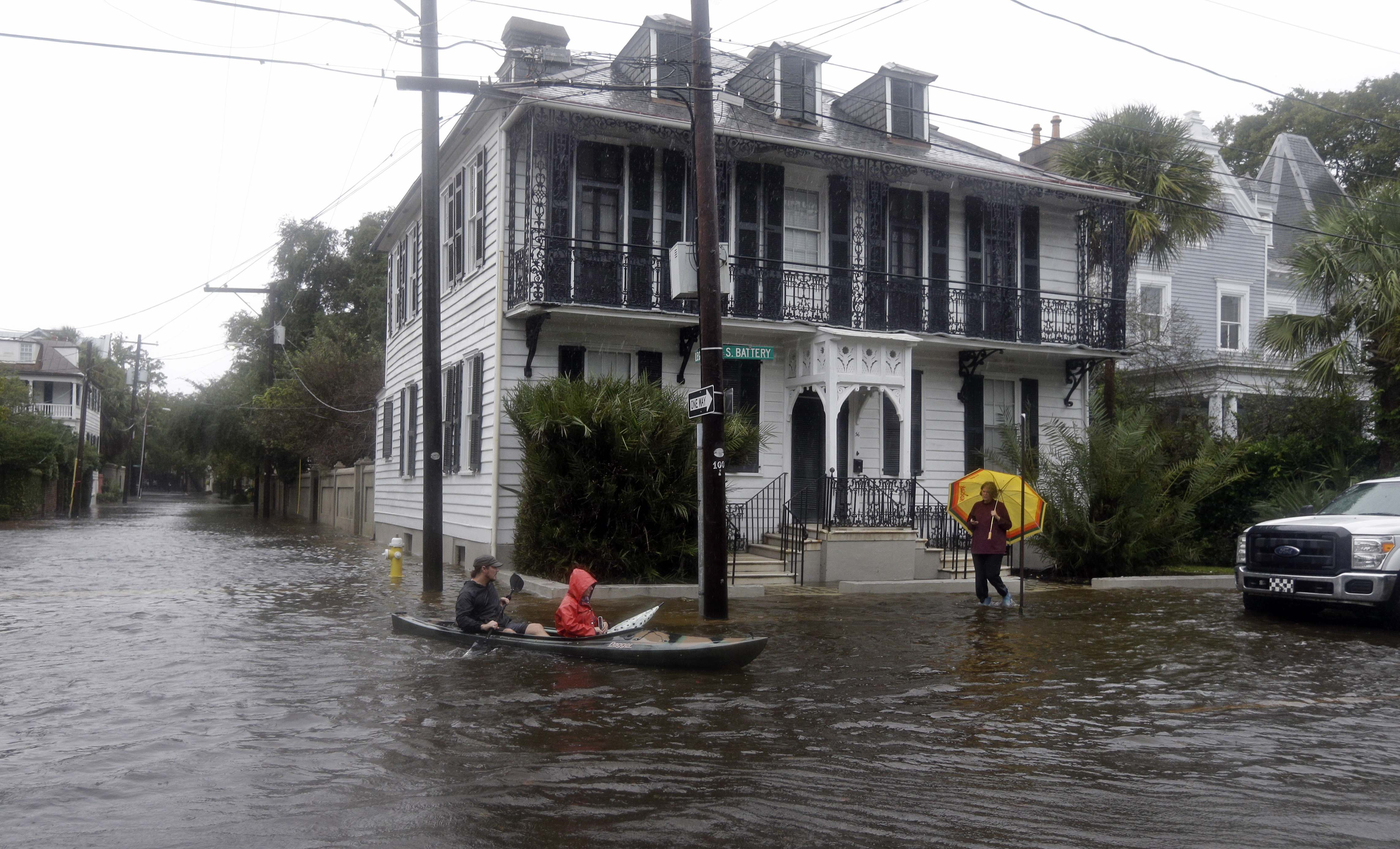Paul Banker, left, paddles a kayak and his wife Wink Banker, as they takes photos on a flooded street in Charleston, S.C., Saturday, Oct. 3, 2015