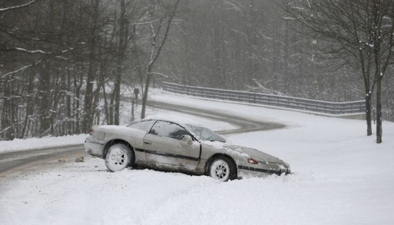 A car rests on the side of the road in the snow Friday, Feb. 1, 2013, in Solon, Ohio.