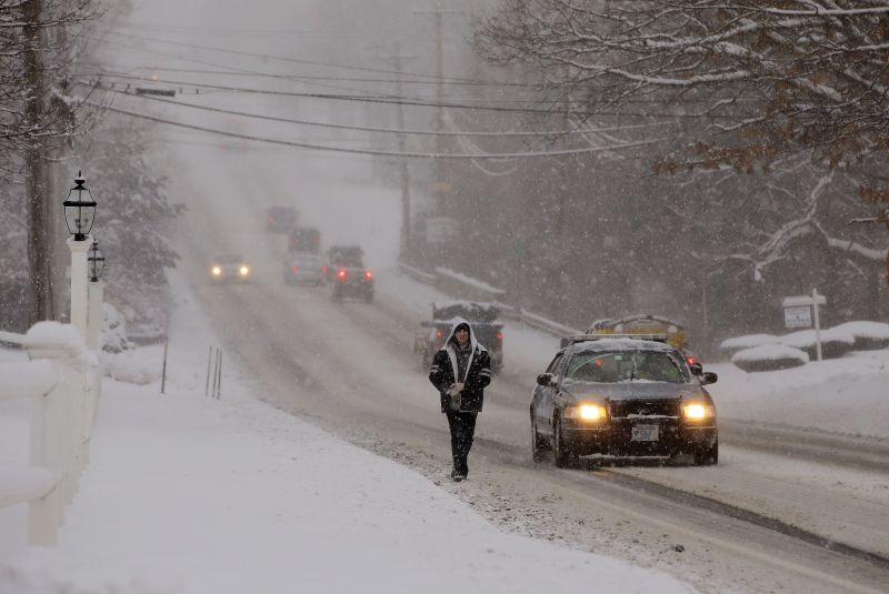 Traffic is sparse and the sidewalks impassable as a heavy snow falls in Pembroke, Mass.