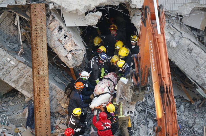 Emergency rescuers remove a body found in a collapsed building 