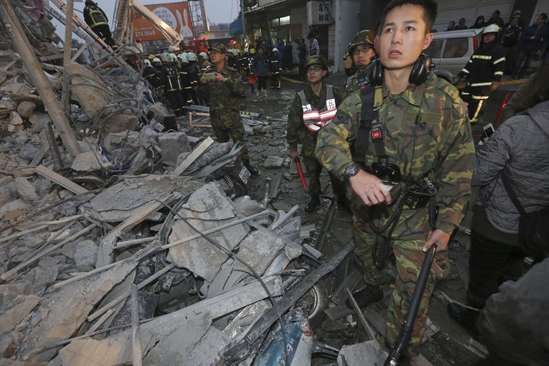 Army soldiers search a toppled building an earthquake in Tainan, Taiwan, Saturday, Feb. 6, 2016. 