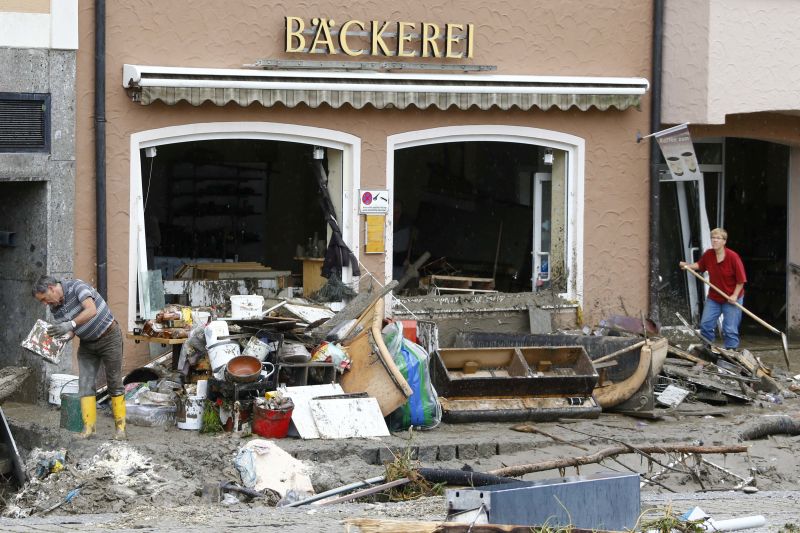 People remove mud from a bakery damaged by floods in Simbach am Inn, Germany