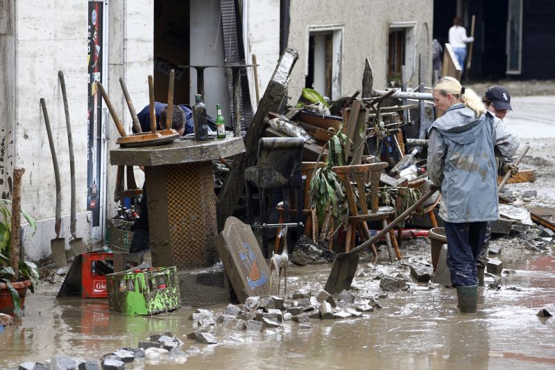 People remove mud from a house damaged by floods in Simbach am Inn, Germany