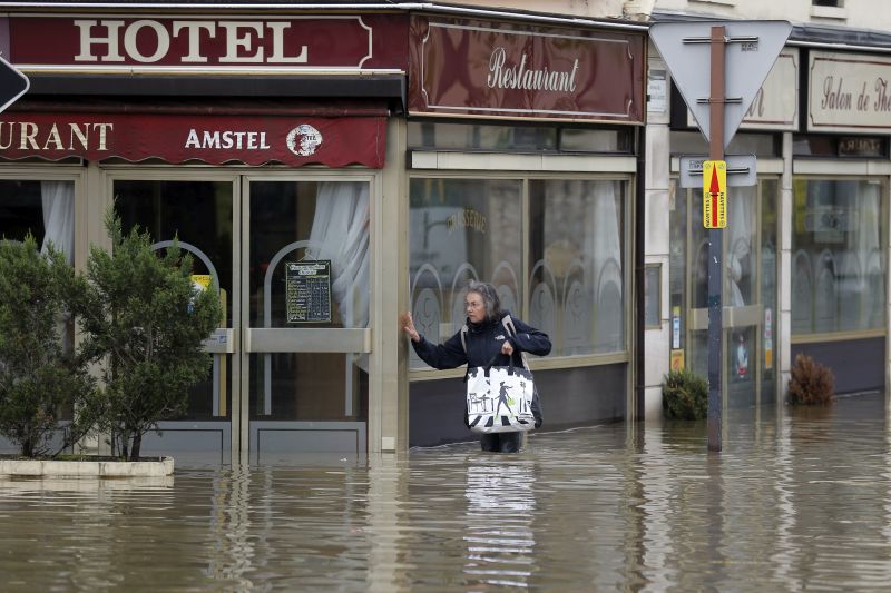 A woman tries to find a way out in a flooded street downtown Longjumeau, south of Paris