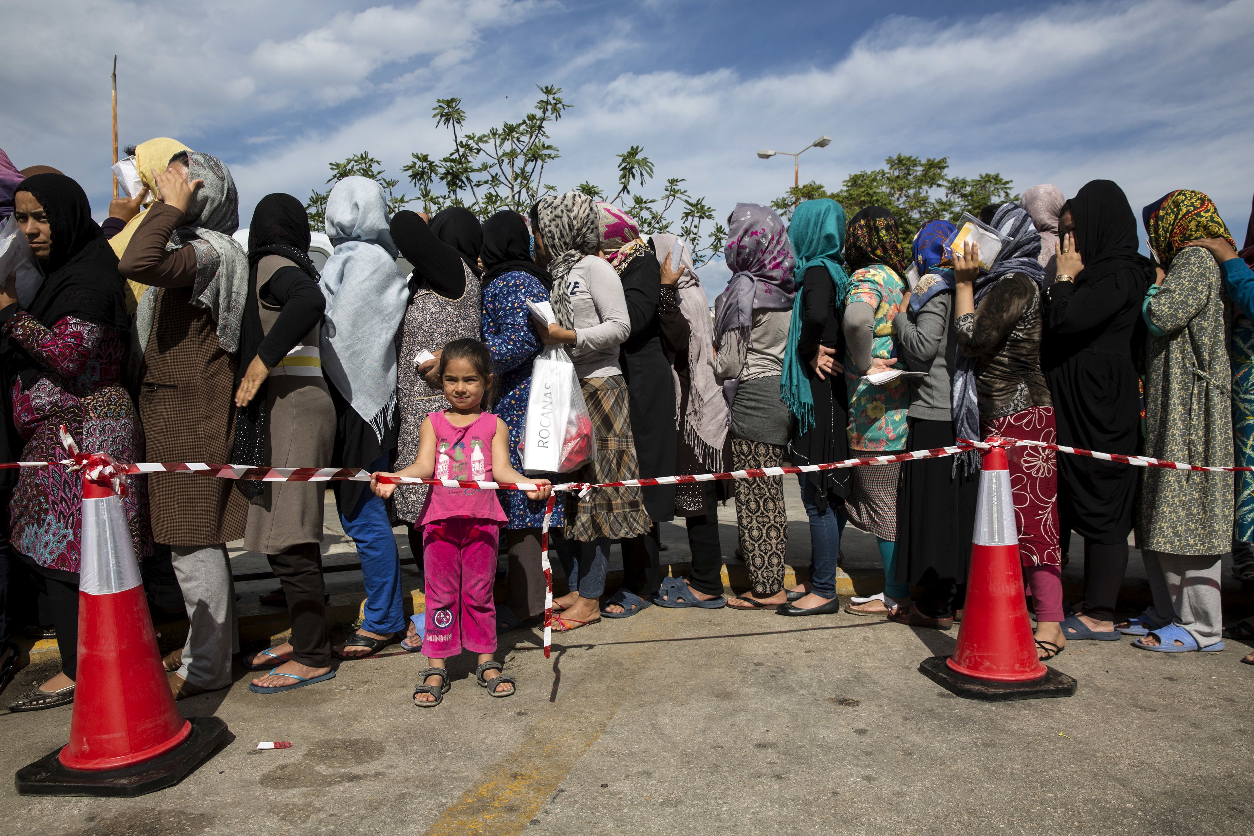 Women queue as they wait for distribution of hygiene kits