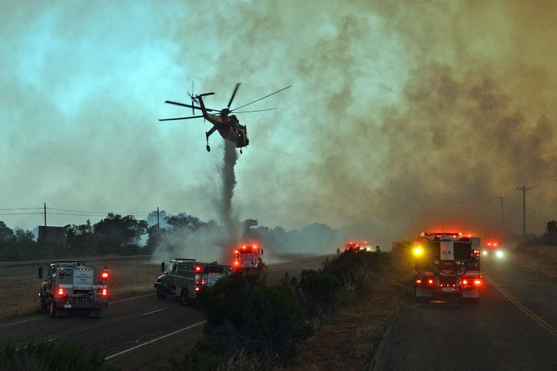 A skycrane helicopter makes an emergency water drop onto the US Highway 101 