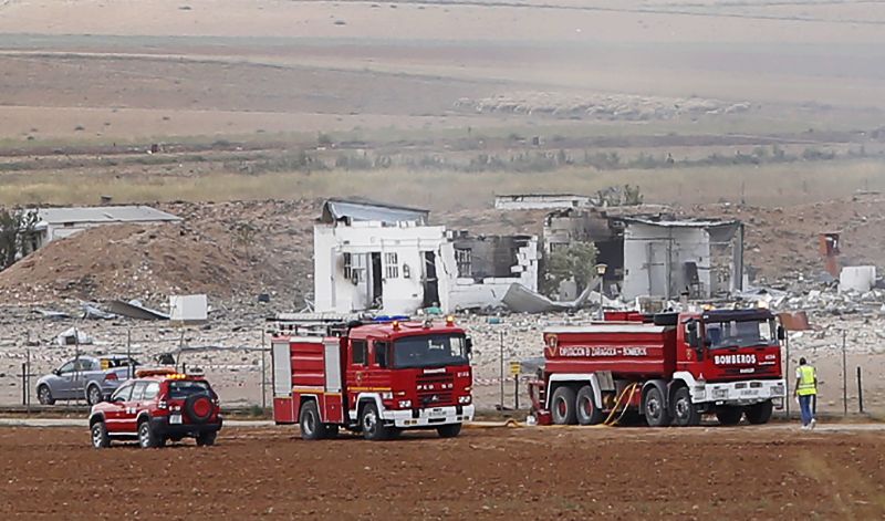 The destroyed fireworks factory Pirotecnia Zaragozana's building is seen behind firefighters trucks 