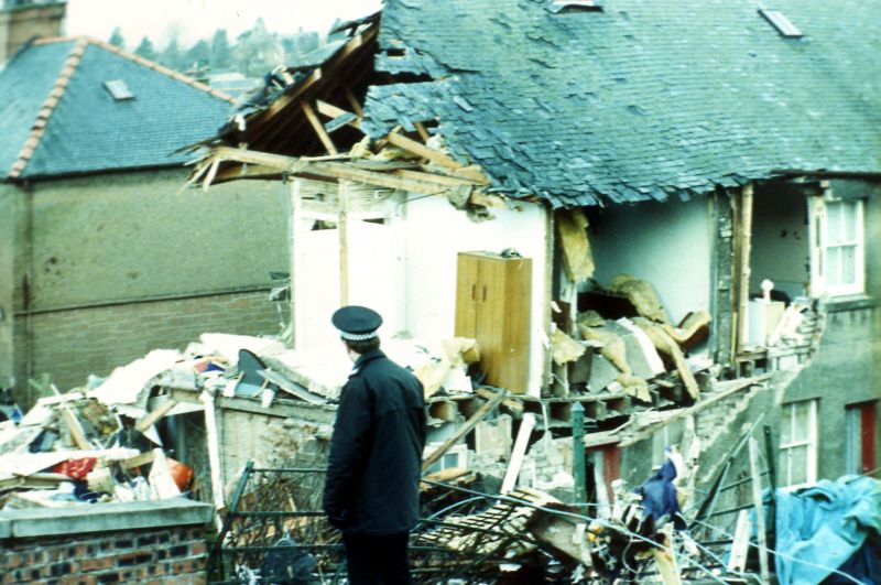 a police officer walks past the damage in Lockerbie, Scotland
