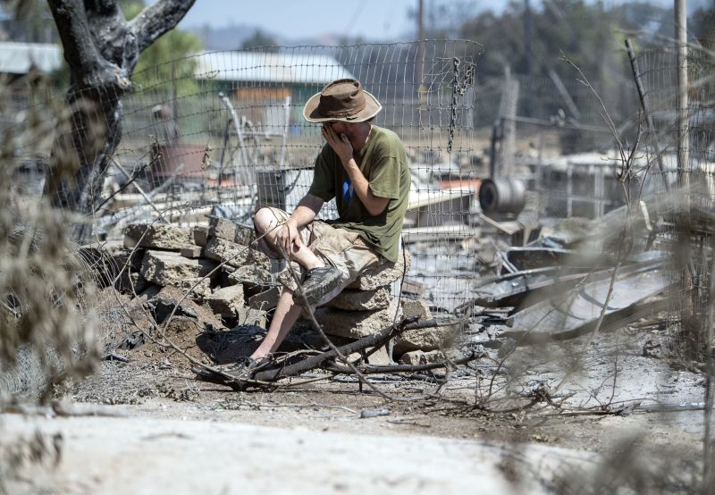 James McCauley weeps as he views the burned out remains of his home