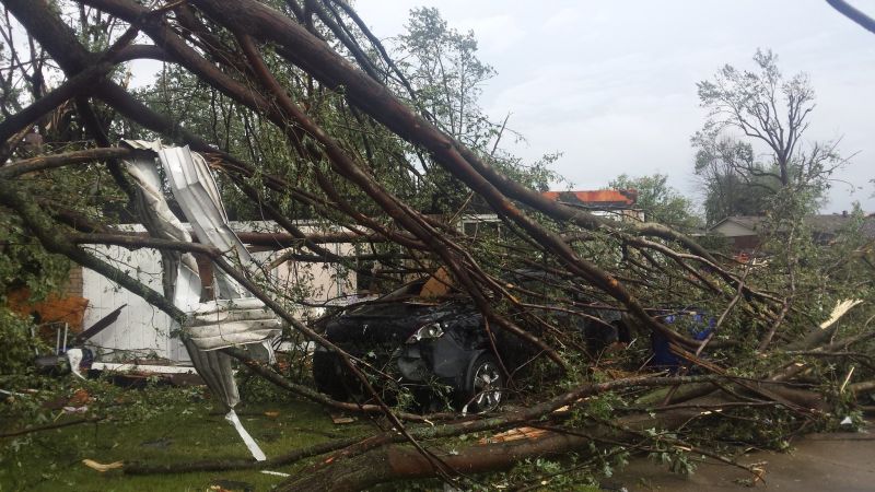 Tree branches rest on top of a vehicle after a tornado struck in Kokomo, Ind.