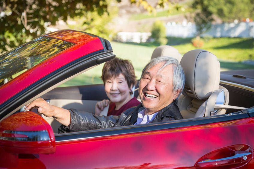 senior couple in red convertible