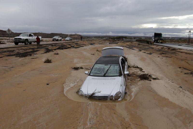 A car is partially buried in mud on Interstate 15 in Moapa, Nev., Monday, Sept. 8, 2014.