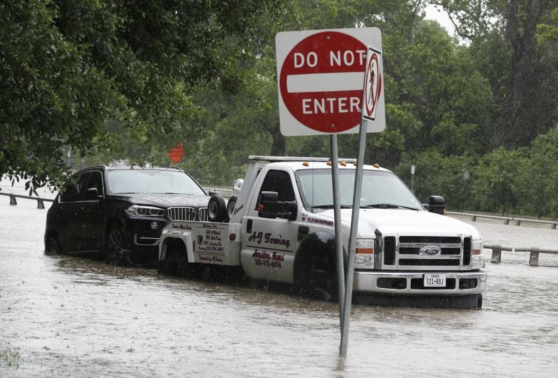  In this April 18, 2016 file photo, a stranded vehicle is towed out of a flooded street in Houston.
