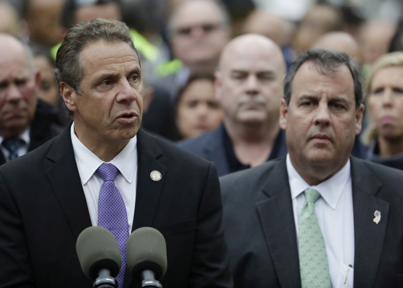 New York Gov. Andrew Cuomo, left, speaks during a news conference on the train crash at the Hoboken Terminal as New Jersey Gov. Chris Christie, right, listens