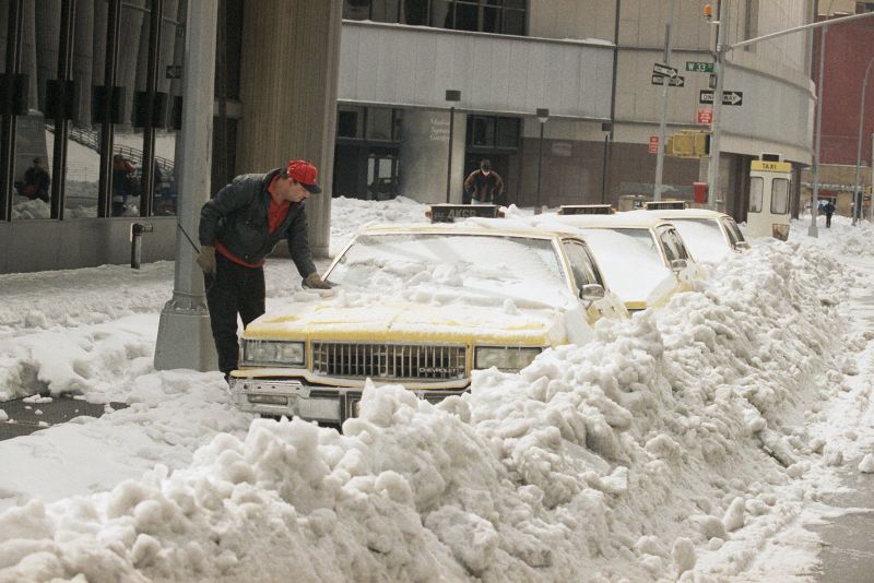 axi driver tries to free his cab from snow