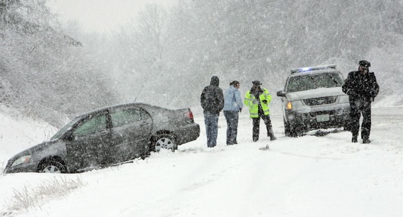 Local police attend to a car that has spun off the road