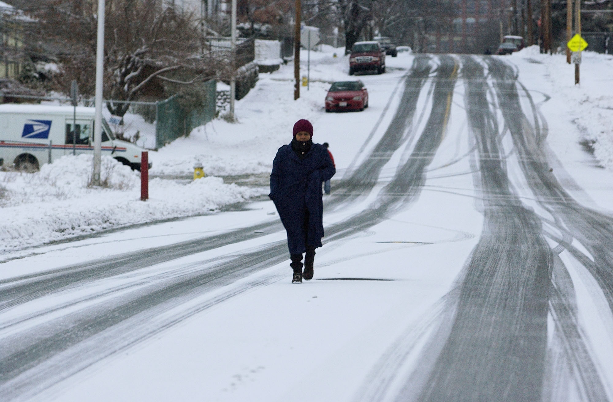 Man walking down middle of snow covered street in Lawrence MA