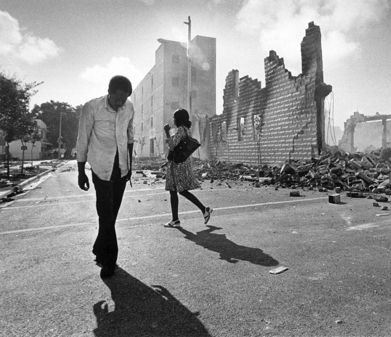 People walk past ruins in the Culmer section of Miami May 19, 1980 after rioting