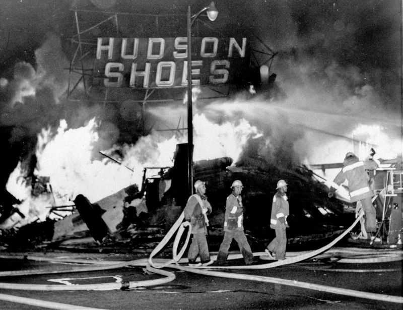 firefighters battle a blaze set in a shoe store during 1965 Watts riots