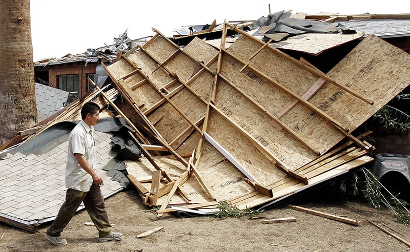 Man looking at damage to his property from sand storm in Arizona