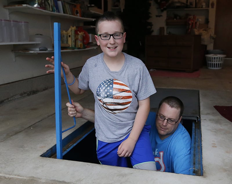 Family emerging from storm shelter in basement of home