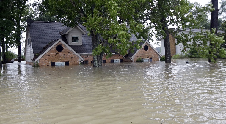 A home is surrounded by floodwaters from Tropical Storm Harvey on Monday, Aug. 28, 2017, in Spring, Texas. (AP Photo/David J. Phillip)