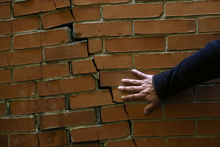 Architect Victor Marquez checks a cracked wall that was not caused by the recent earthquake during his survey of a seven-floor apartment building, in Mexico City's Roma neighborhood, Friday, Sept. 22, 2017. It is up to experts like architect Víctor Marquez, who thinks of himself as a building doctor, to bring peace of mind, or recommend aggressive treatment, to fearful apartment dwellers in the aftermath of Mexico's 7.1 magnitude quake that struck on Sept. 19. (AP Photo/Marco Ugarte)