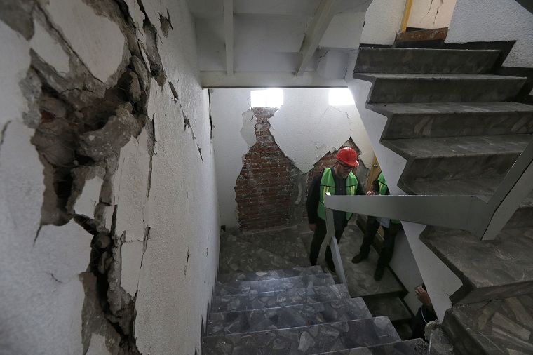 Architects Victor Marquez stands in a stairwell during the appraisal of an earthquake-damaged building, in Mexico City, Friday, Sept. 22, 2017. It is up to experts like Marquez, who considers himself a building doctor, to bring peace of mind to fearful apartment dwellers living in the aftermath of a powerful Sept. 19 earthquake. (AP Photo/Marco Ugarte)