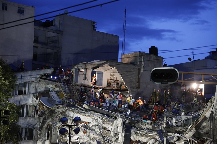 Rescuers race to save people believed to be still alive inside a collapsed office building in the Roma Norte neighborhood of Mexico City, as night falls Friday, Sept. 22, 2017, three days after a 7.1 magnitude earthquake. Hope mixed with fear Friday in Mexico City, where families huddled under tarps and donated blankets, awaiting word of their loved ones trapped in rubble. (AP Photo/Rebecca Blackwell)