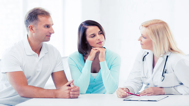 Man and woman consulting with female doctor