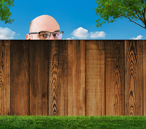 Bald-white-man-with-glasses-looking-over-fence