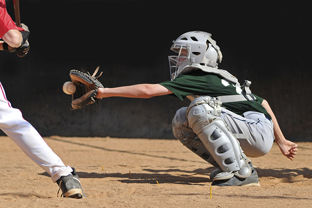 Boy playing catcher in little league baseball game