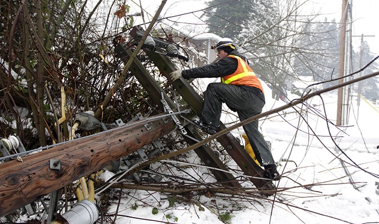 Man climbing up downed power pole
