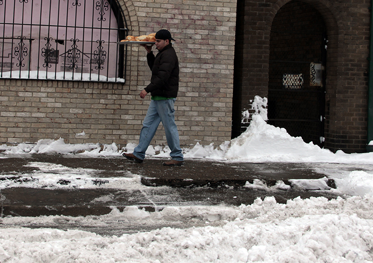 Man delivering bread walking on icy sidewalk