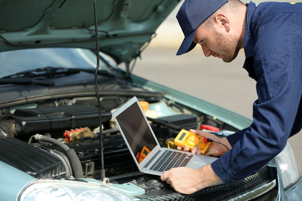 mechanic conducting a diagnostic scan of a vehicle