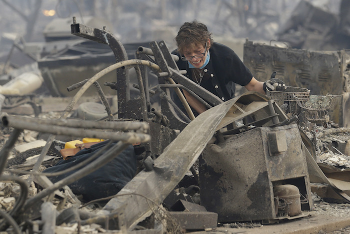 wildfire victim sorts through rubble